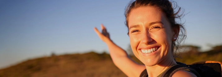 A woman smiling while outside.